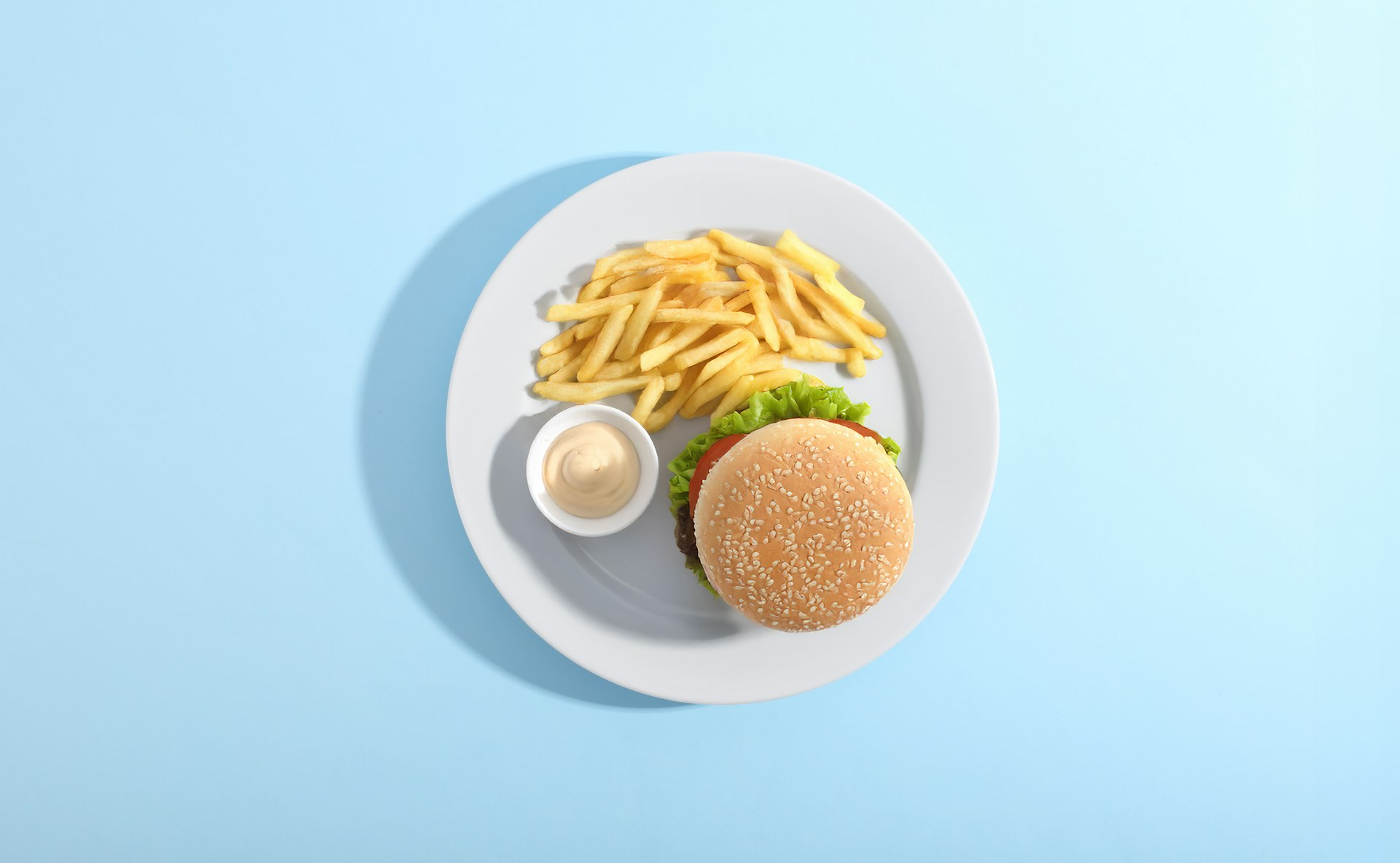 Burger, fries, and sauce on a plate.